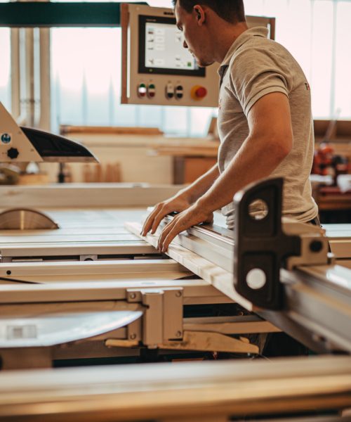 Mitarbeitern beim Arbeiten an einer Maschine in der Tischlerei